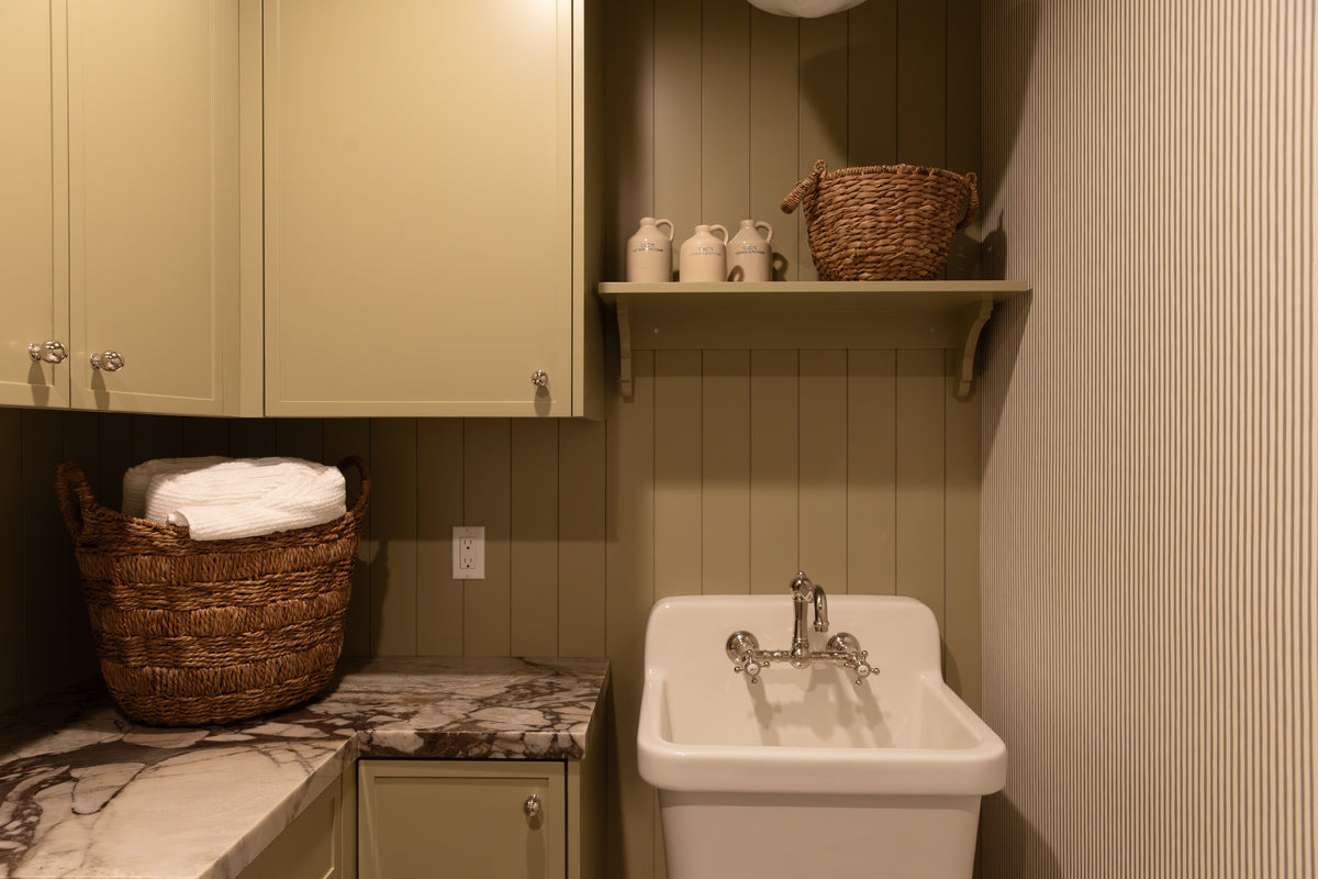 Custom laundry room cabinetry, marble slab countertops, and open shelving styled by B Farm Design for a full-scale residential rebuild. 